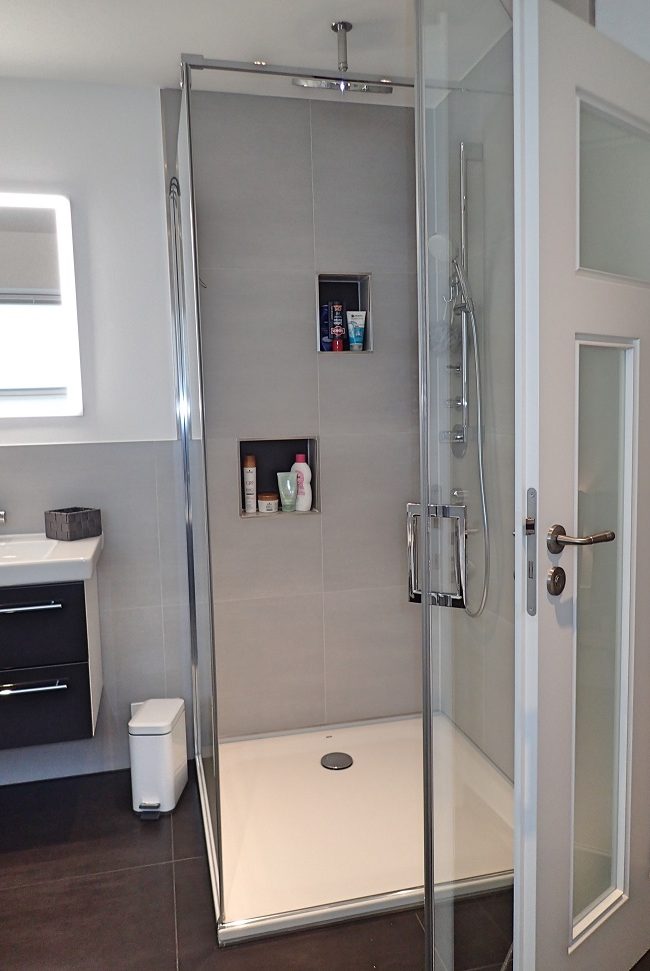 Moderner Duschbereich mit integrierten Duschfächern